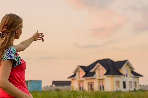 Kind läuft mit ausgebreiteten Armen auf ein Wohnhaus zu
