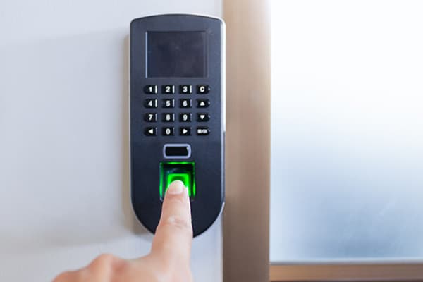 Finger legt sich auf den Fingerabdrucksensor eines Zutrittsterminals