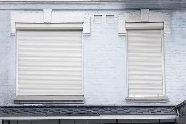 Hausfassade mit heruntergelassenen Rollläden