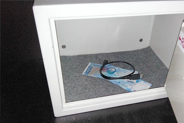 Geöffneter Wandtresor mit Geldschein