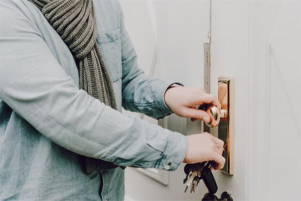 Person schließt eine Wohnungstür von innen ab