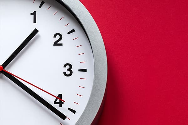 Wanduhr vor rotem Hintergrund